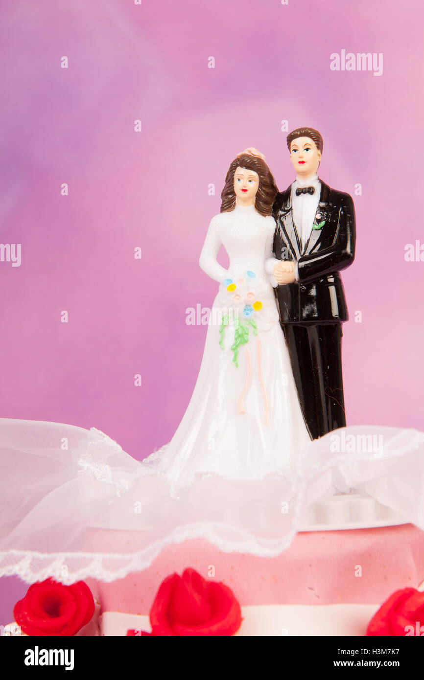 Couple on top of wedding cake Stock Photo