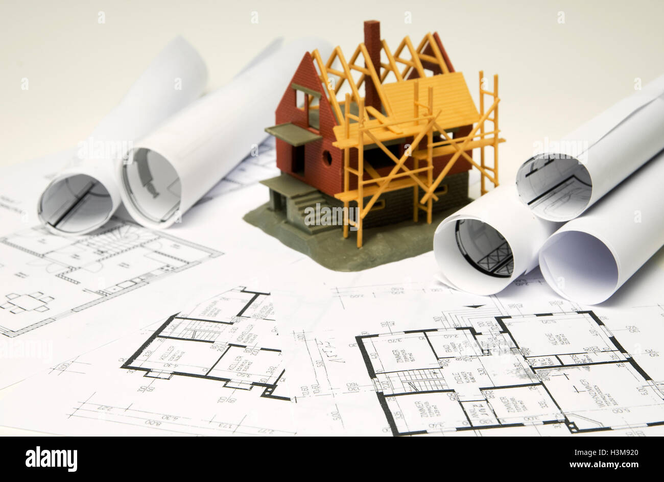 Architectural model of a building shell on blueprints Stock Photo - Alamy