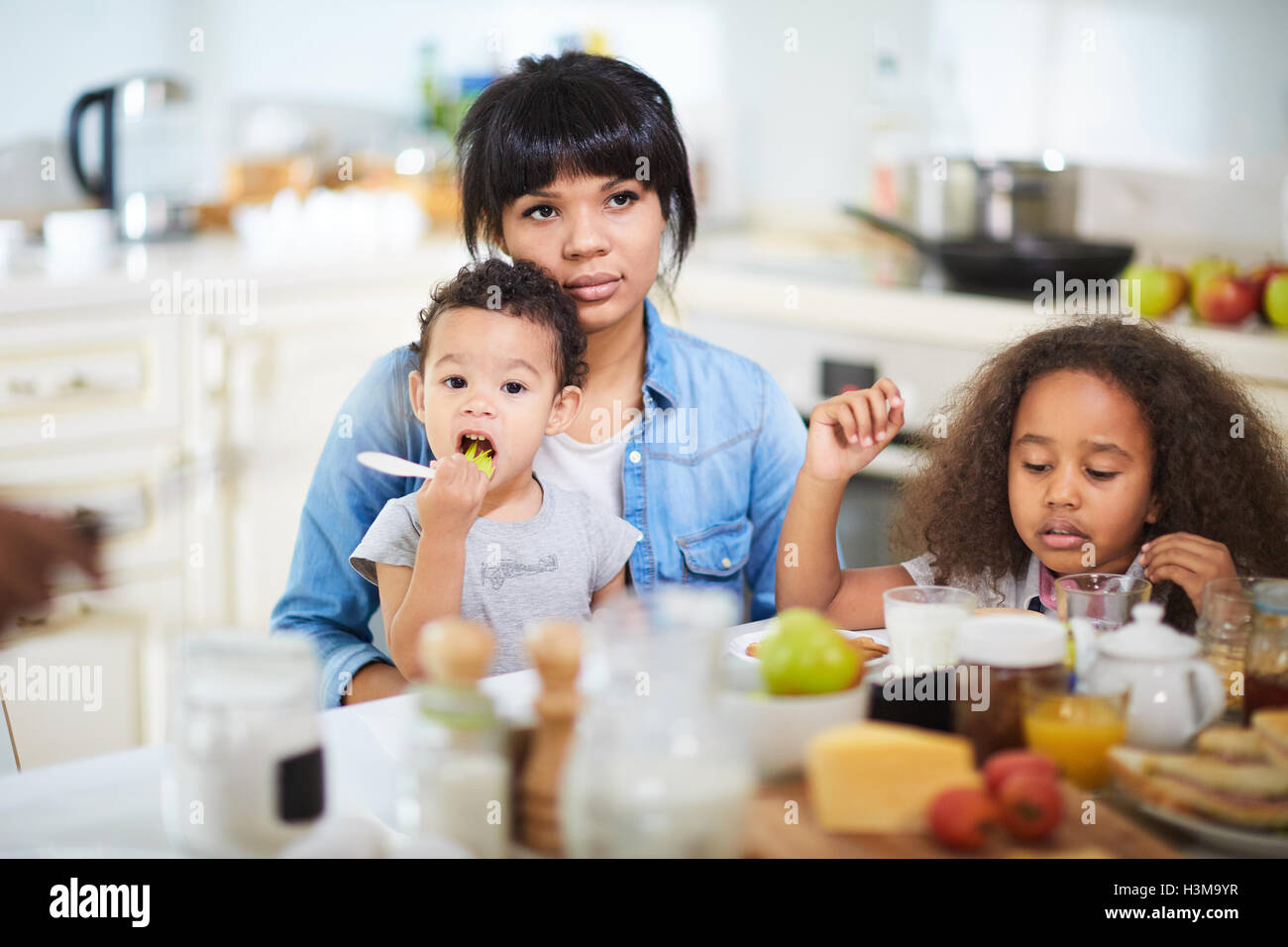 Mixed-race family having breakfast in the kitchen Stock Photo - Alamy