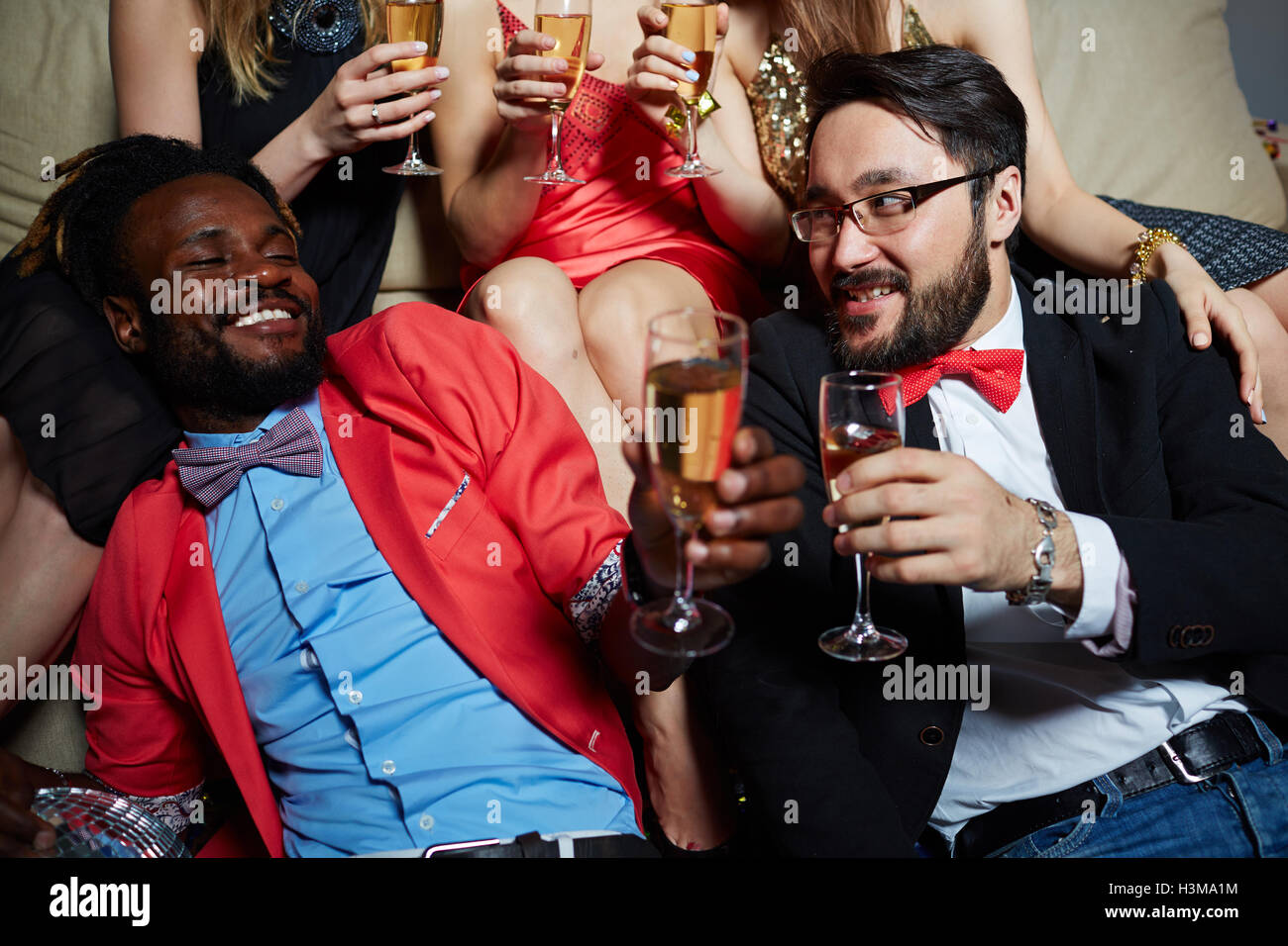 Two posh guys cheering with champagne at booze Stock Photo