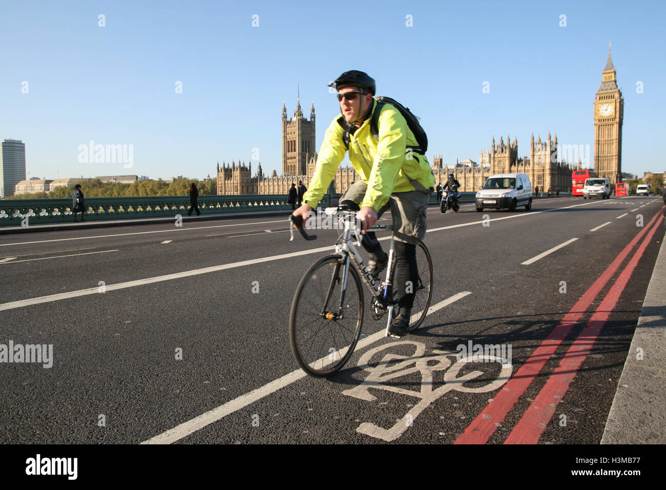 Cyclist rides along bicycle path on Westminster Bridge, with Houses of ...