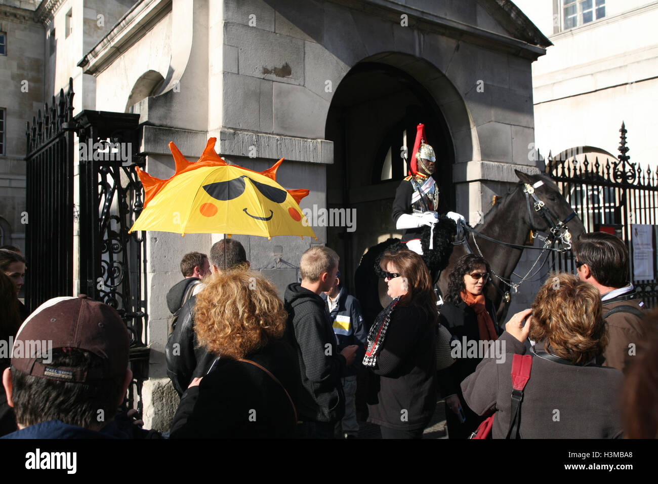 Tour leader holding umbrella and tourists at,horse guard,horseguard, Horse Guards, Whitehall, Westminster, London. Sunny morning in October. Stock Photo