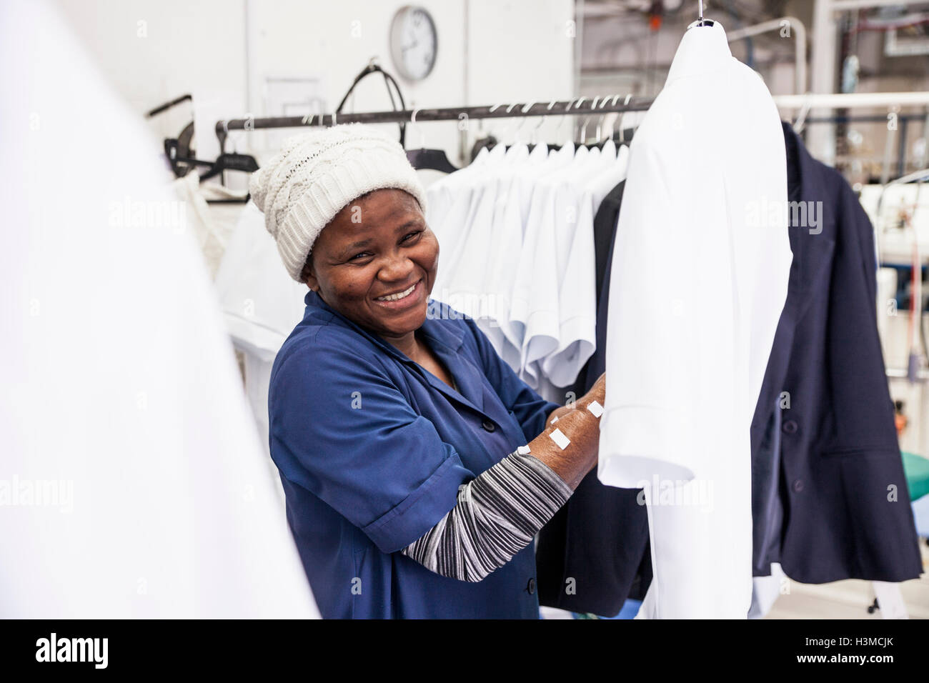 Worker examining shirt in garment factory Stock Photo