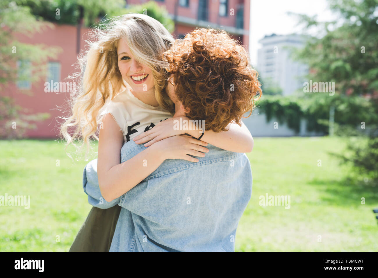 Couple hugging in park Stock Photo - Alamy