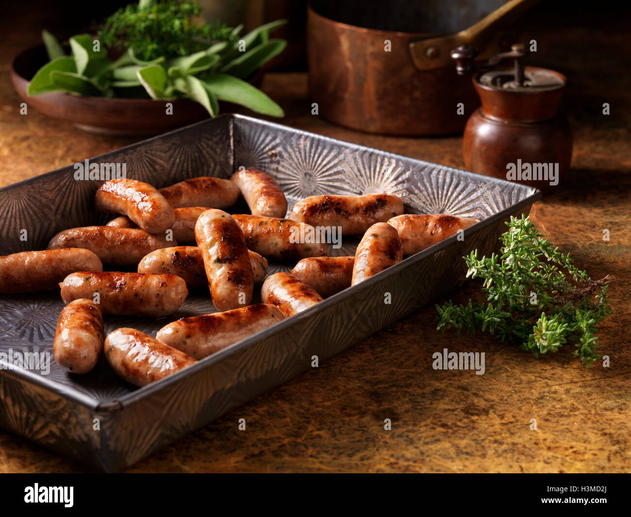 Christmas, celebration food, classic cocktail sausage selection, in baking tray, fresh thyme and sage Stock Photo