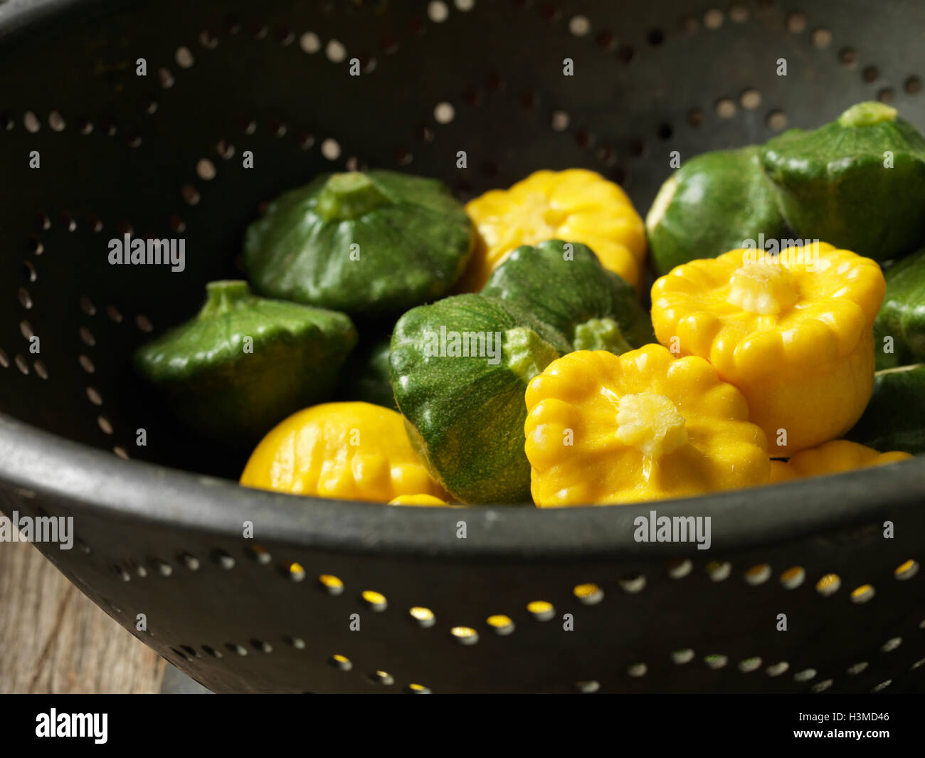 Fresh organic vegetables, patty pans yellow and green in metal colander Stock Photo