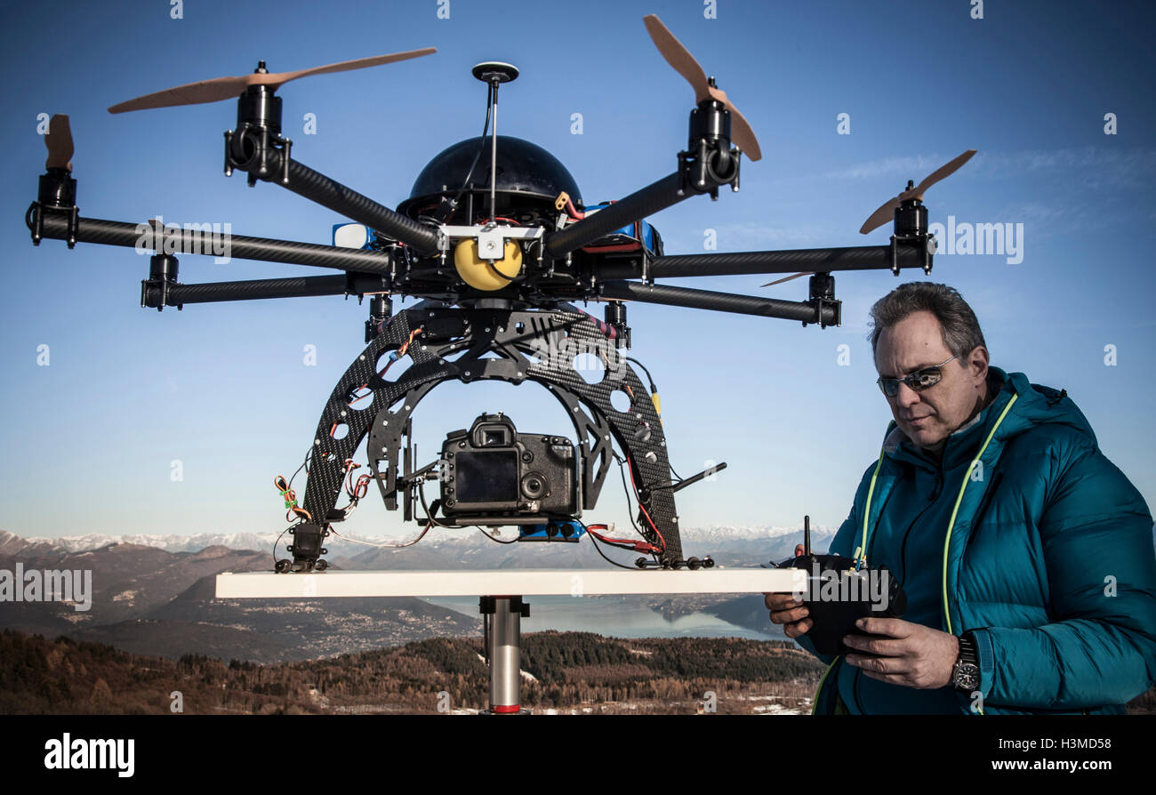 Mature man preparing to fly drone, Stresa, Piedmont, Italy Stock Photo