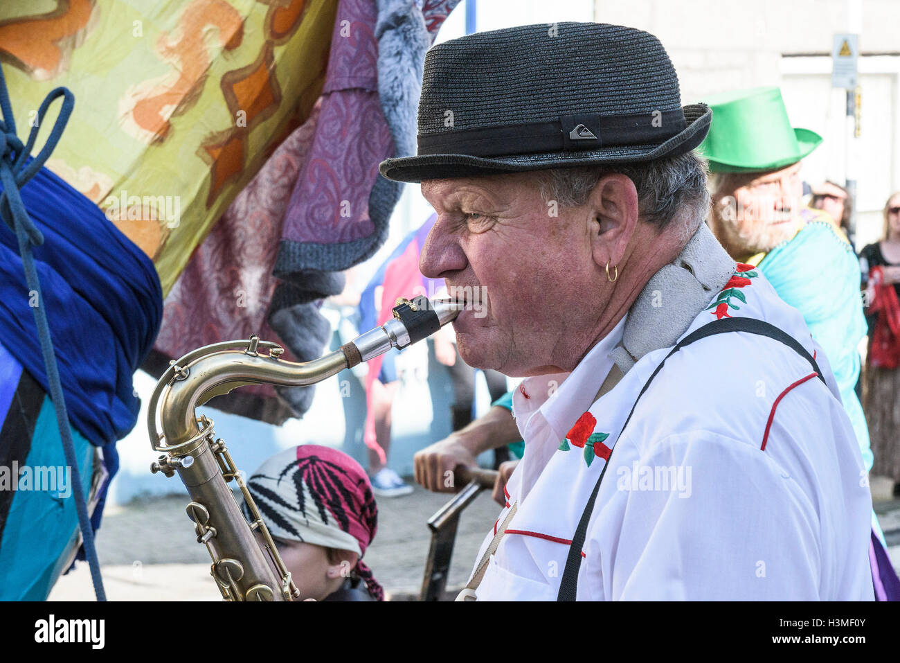 A saxophonist plays during the procession in the Penryn Festival in Cornwall Stock Photo