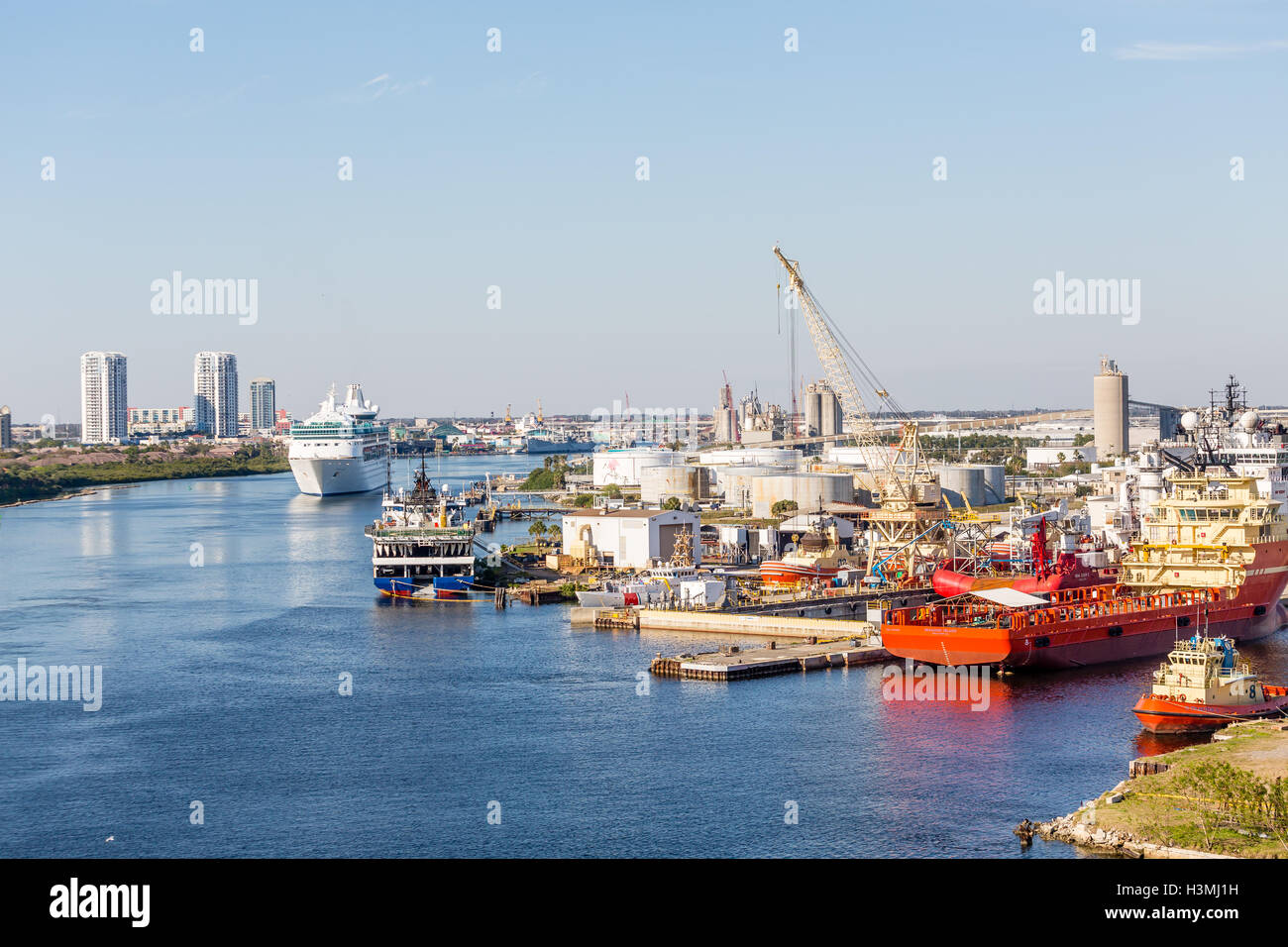 Cruise Ship Sailing Past Industrial Port near Tampa Stock Photo