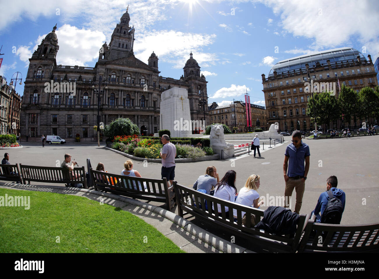 George Square and the city chambers with the cenotaph in Glasgow city center  centre locals and tourists relax and enjoy the sun Stock Photo