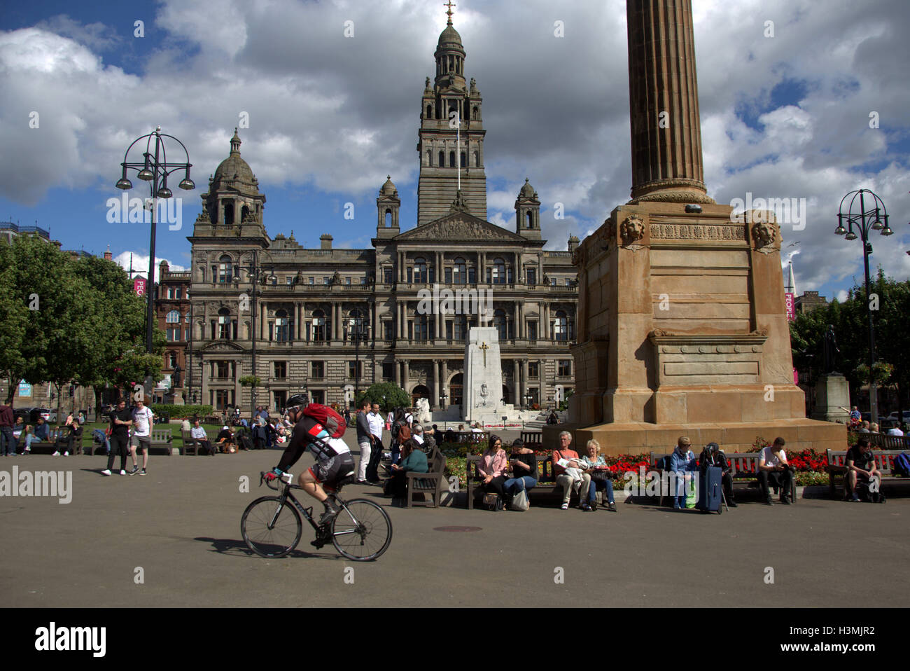 George Square and the city chambers with the cenotaph in Glasgow city center  centre locals and tourists relax and enjoy the sun Stock Photo