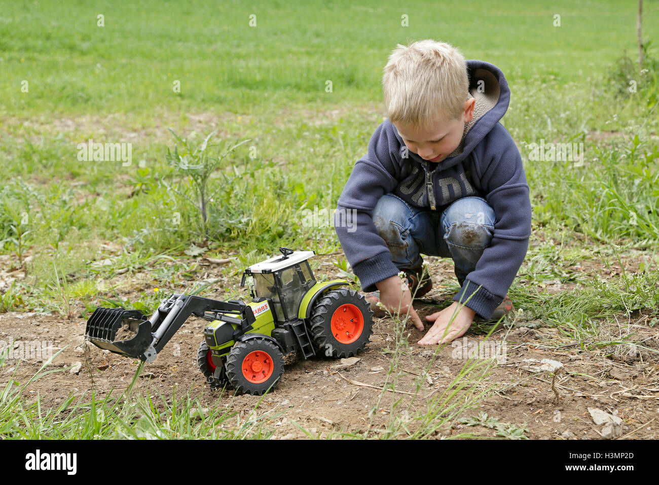 little boy playing with toy tractor Stock Photo