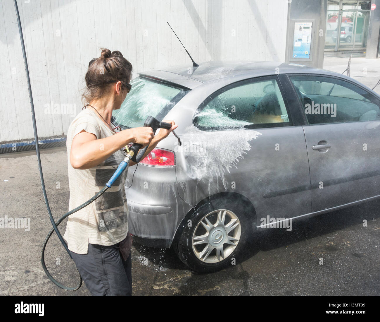 Woman washing car with pressure washer Stock Photo