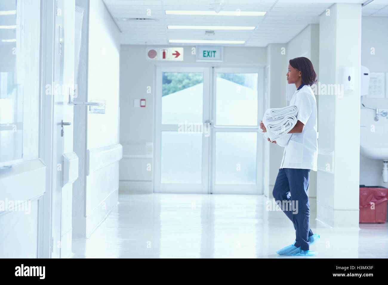 Female orderly carrying towels on hospital corridor Stock Photo Alamy