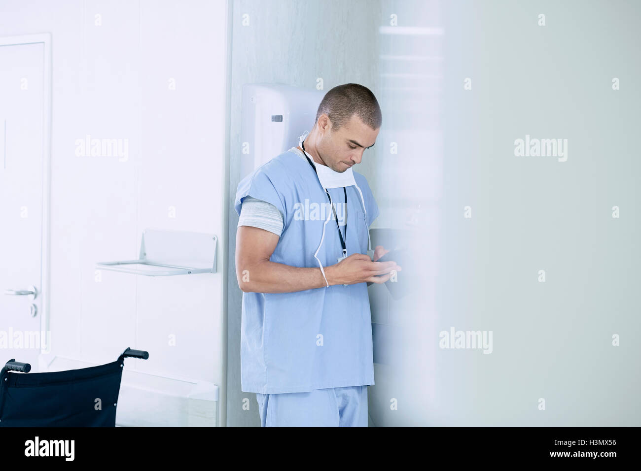 Male medic using smartphone  in hospital ward Stock Photo