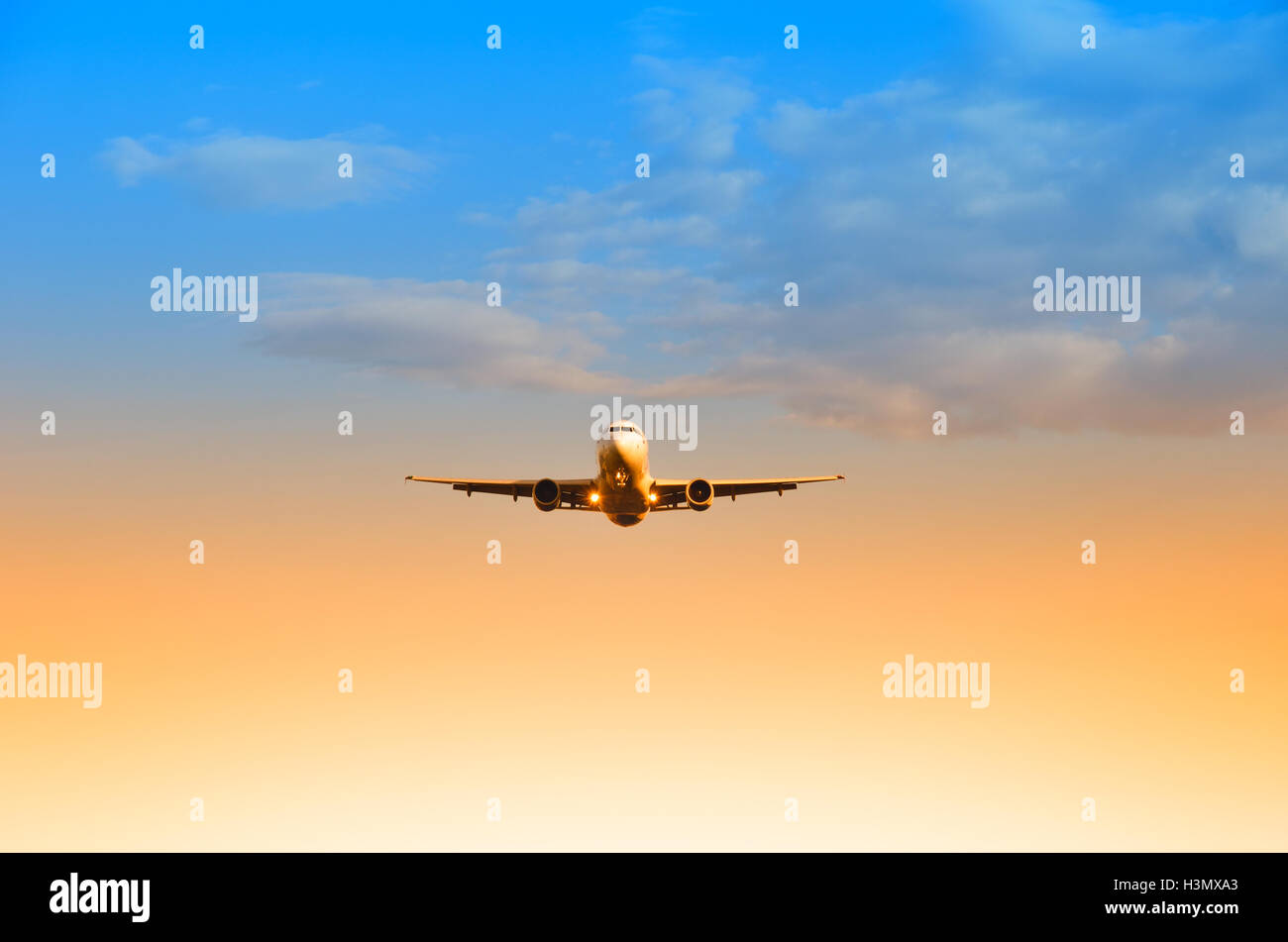 airplane in the sky at sunset Stock Photo