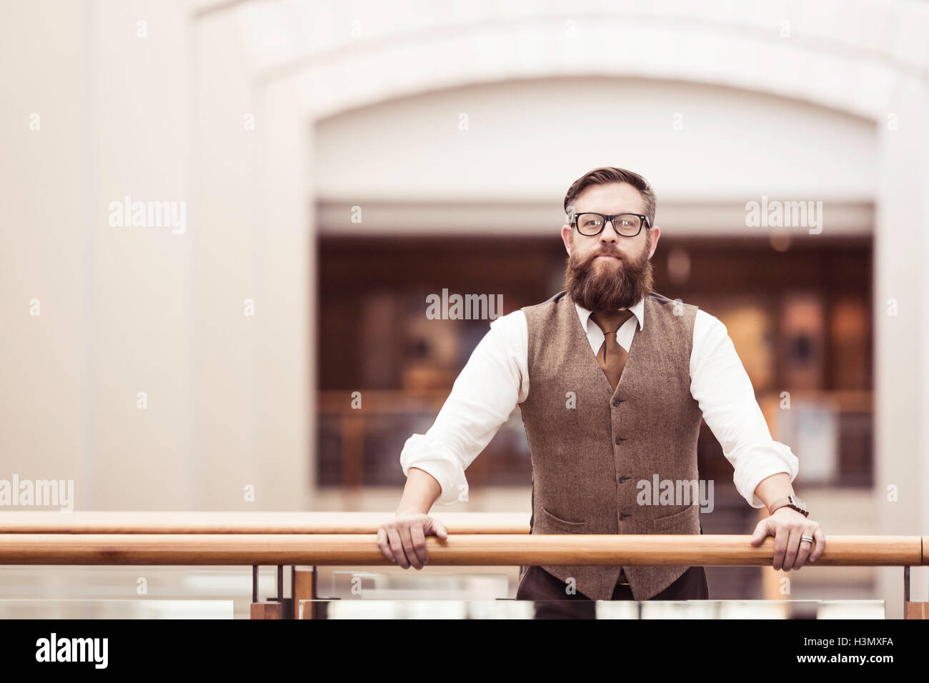 Portrait of bearded businessman wearing tweed waistcoat on office balcony Stock Photo