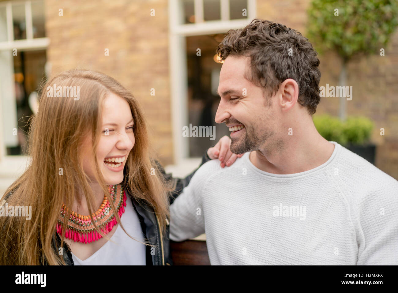 Happy young couple on park bench Stock Photo - Alamy