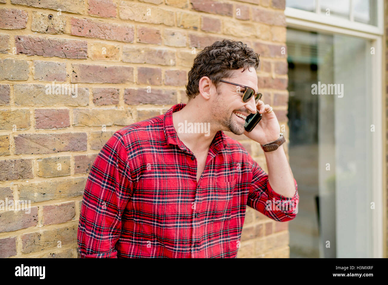 Young Man In Front Of Brick Wall Talking On Smartphone Stock Photo Alamy young-man-in-front-of-brick-wall-talking-on-smartphone-stock-photo-alamy