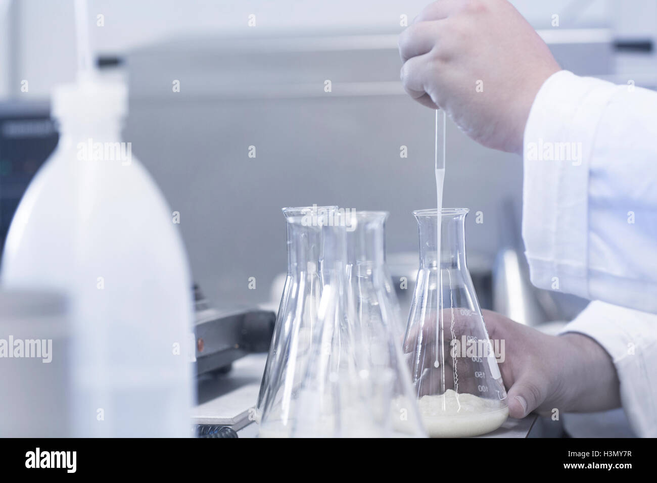 Scientist pipetting sample into beaker in laboratory Stock Photo Alamy