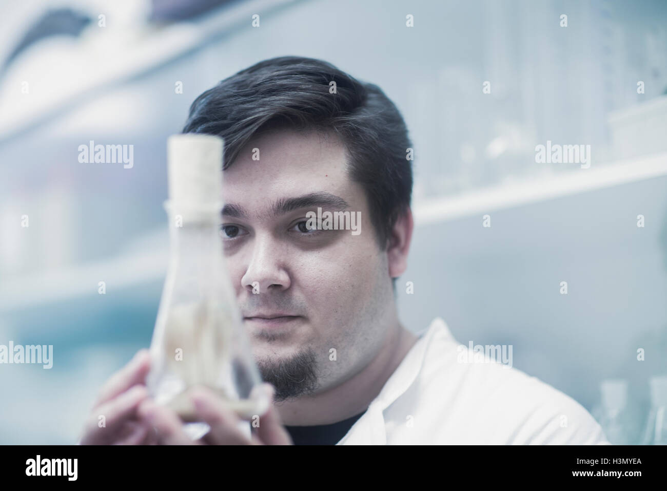 Scientist examining sample in beaker Stock Photo Alamy