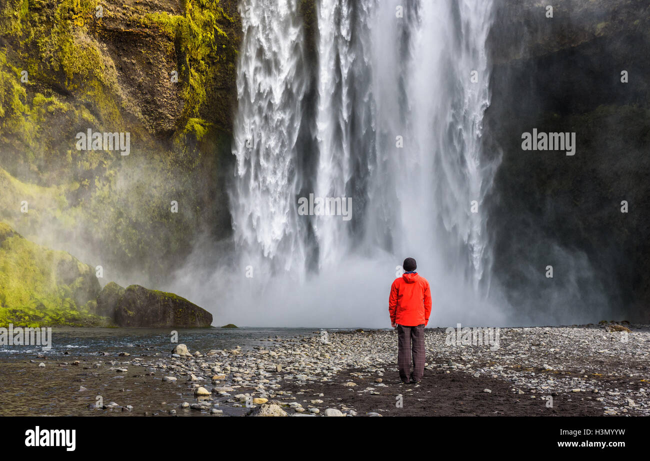 Tourist looking at the famous Skogafoss waterfall in southern Iceland Stock Photo
