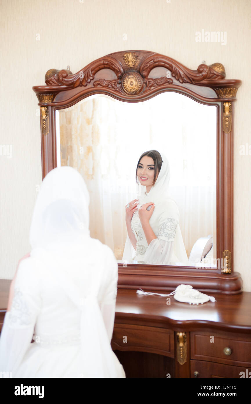 Young Girl In Hijab Looks At Herself In The Mirror Stock Photo