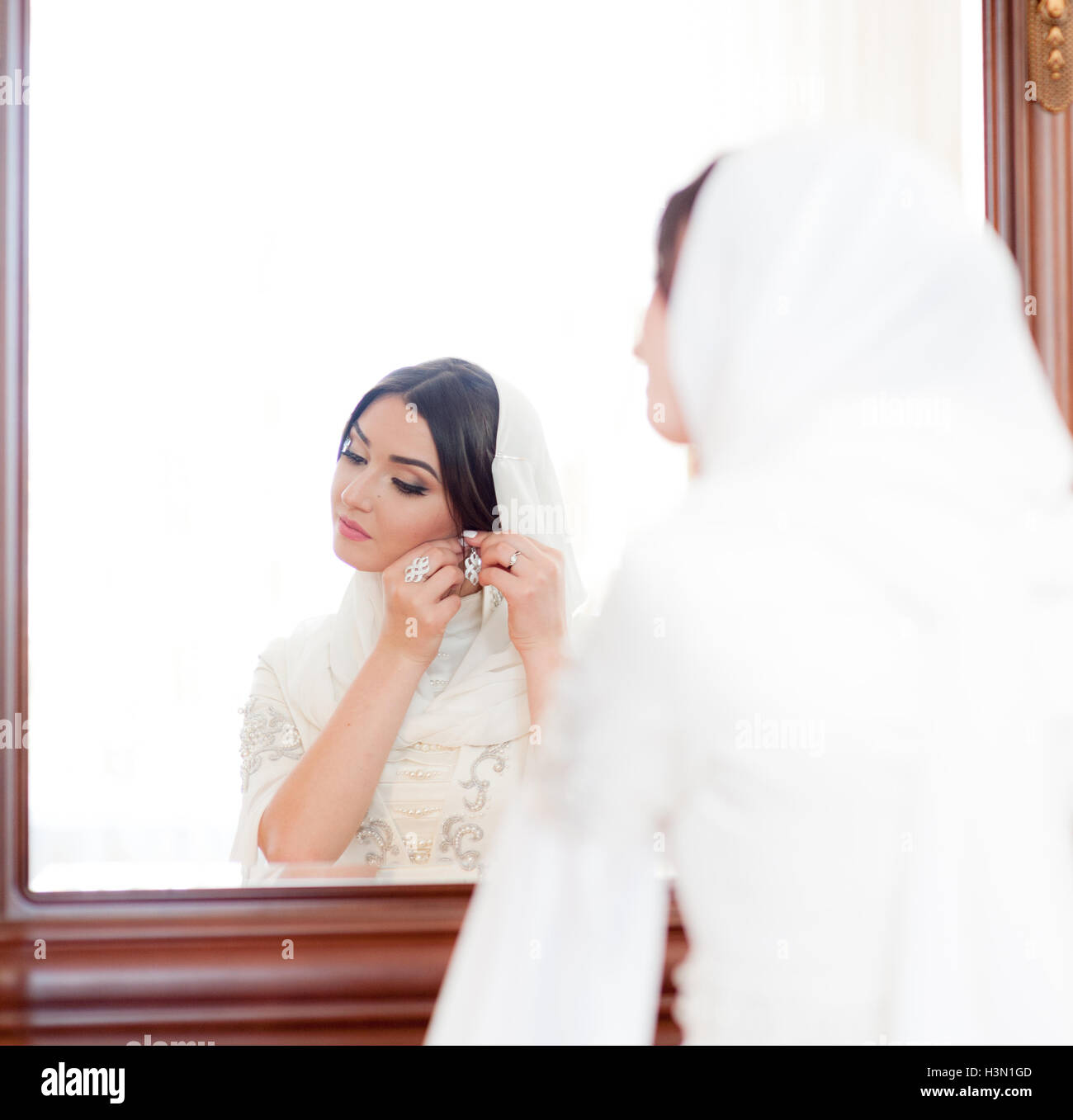 Beautiful Bride In White Hijab Puts On Earrings Stock Photo