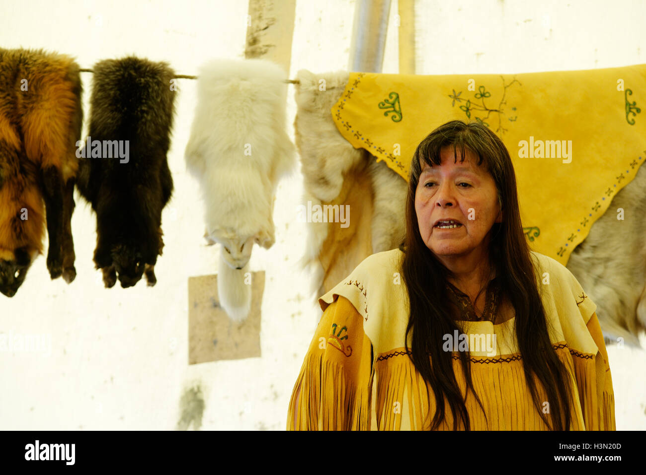 A native american (Micmac) woman speaking in a wigwam, with traditional objects & furs. Kouchibouguac NP New Brunswick Canada Stock Photo