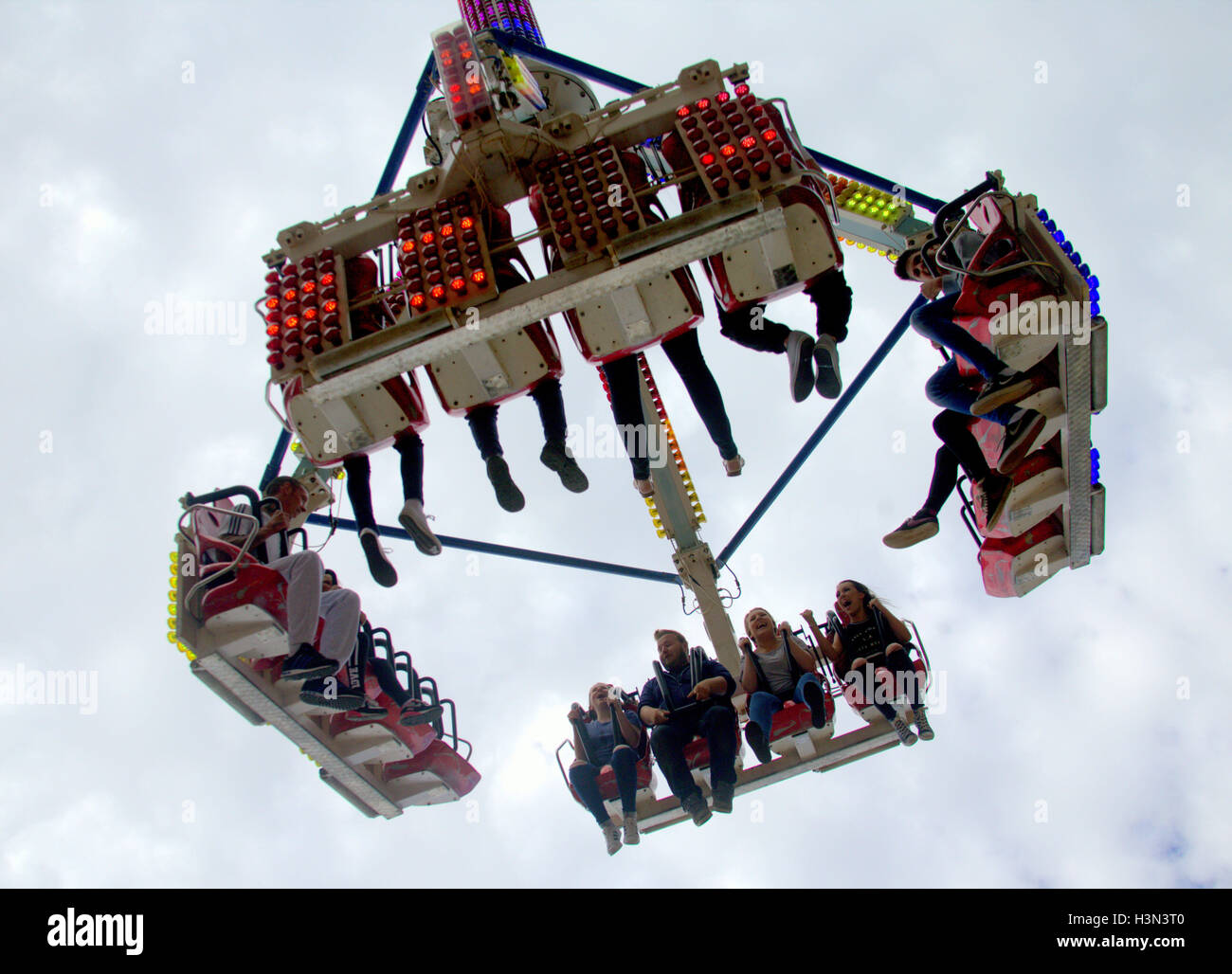 Fairground Rides High fairground ride with people boys and girls being lifted and spun on an ...