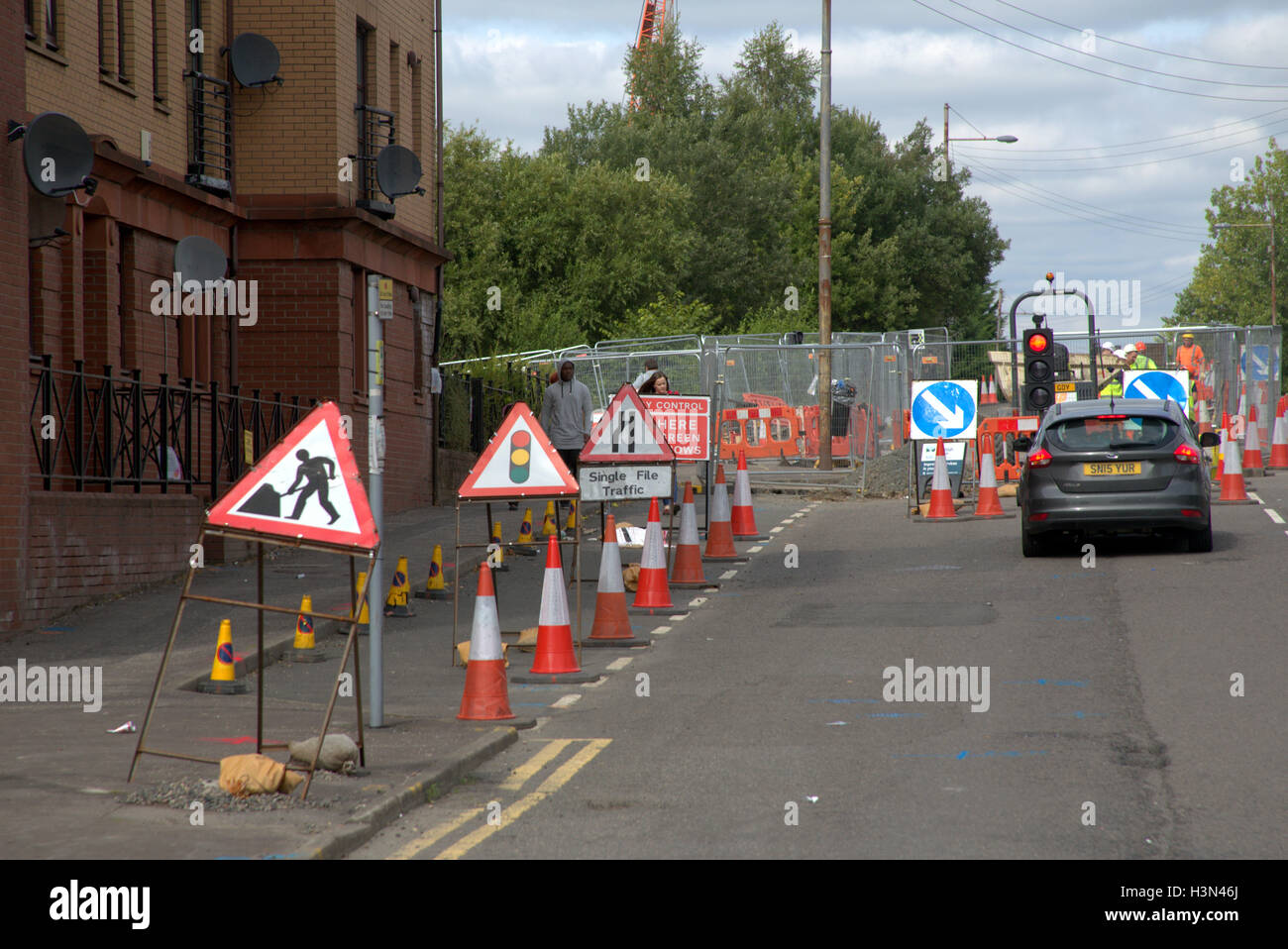 roadworks with men at work sign and traffic cones Stock Photo