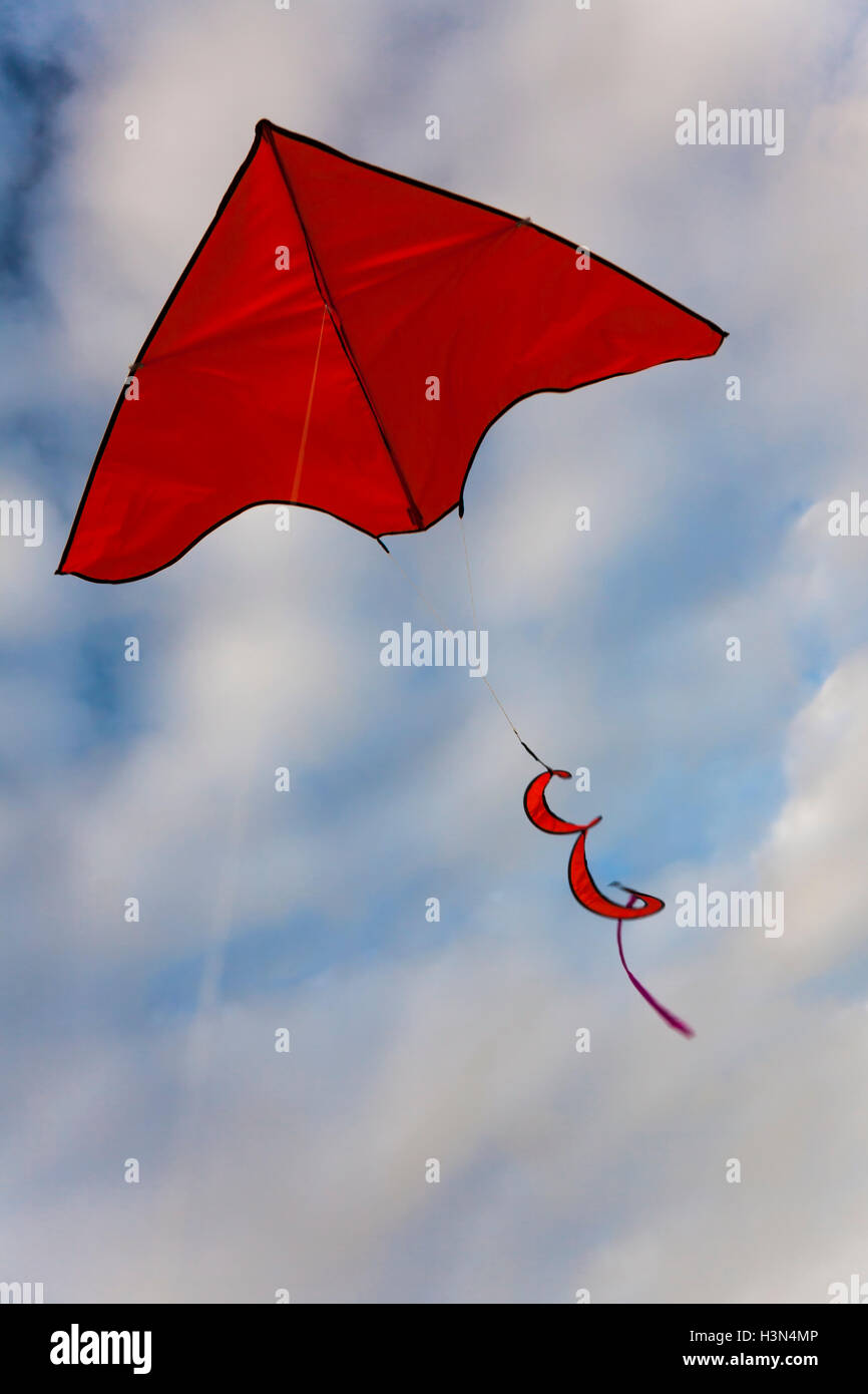 Red kite flying in blue sky with clouds Stock Photo Alamy