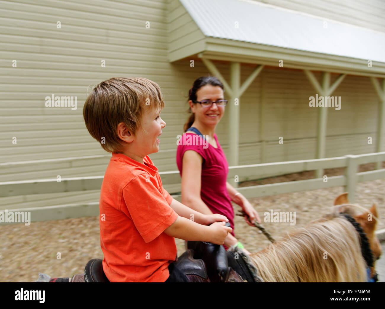 A proud mum and her four year old son on his first pony ride Stock Photo