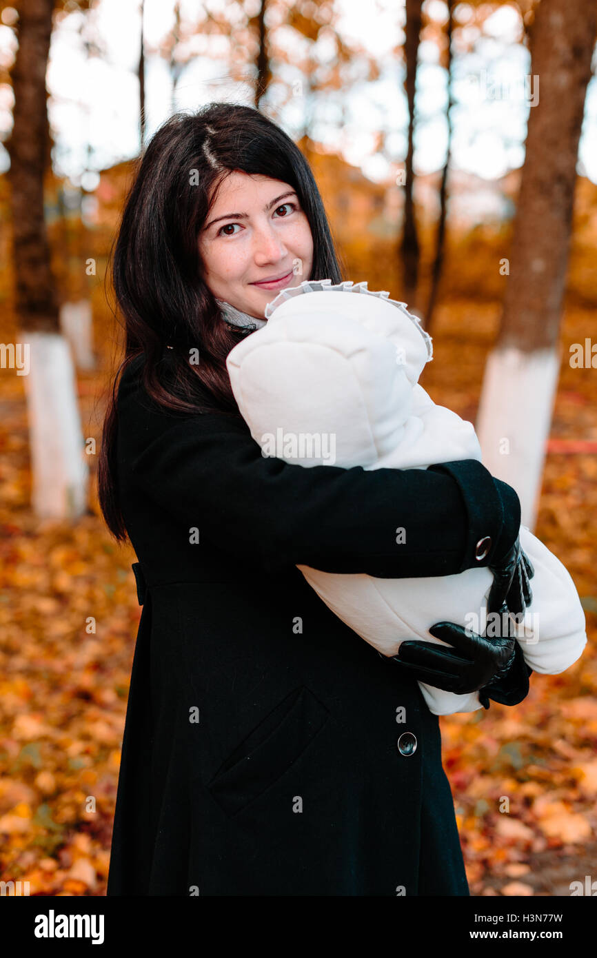 Young mother with her little baby on hand in autumn park Stock Photo ...
