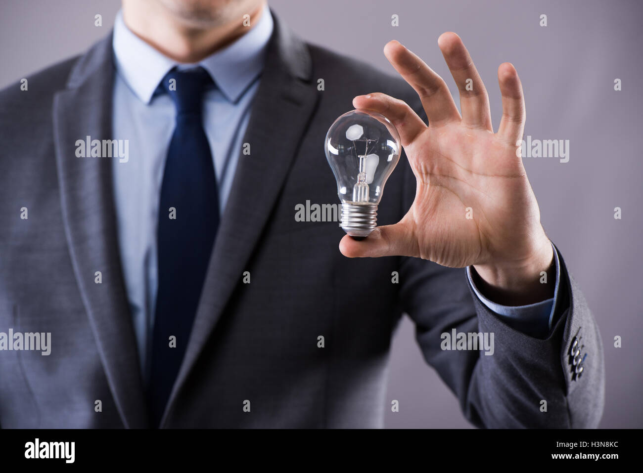Businessman holding light bulb in creativity concept Stock Photo - Alamy