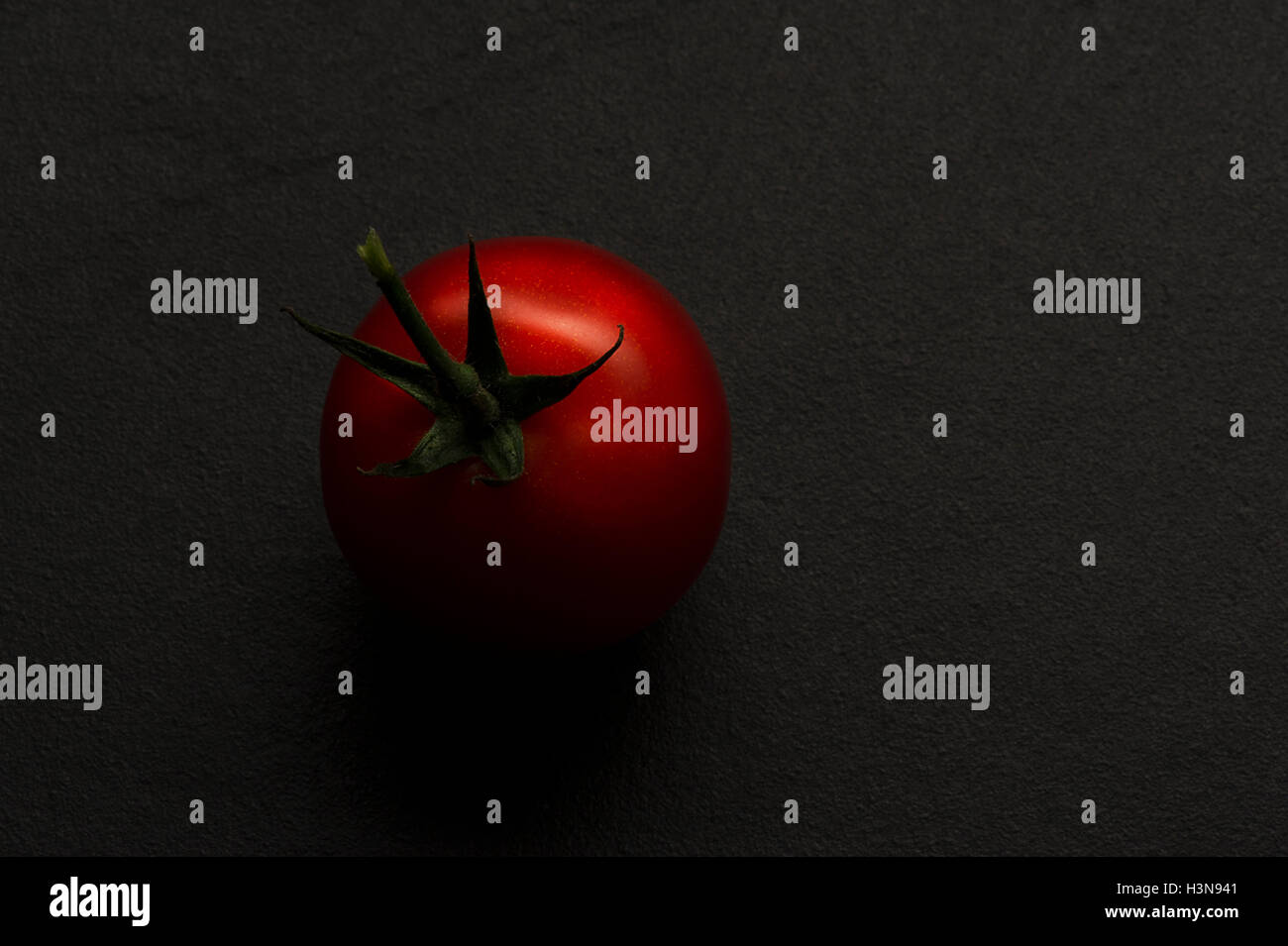 Single ripe red hothouse tomato Stock Photo - Alamy