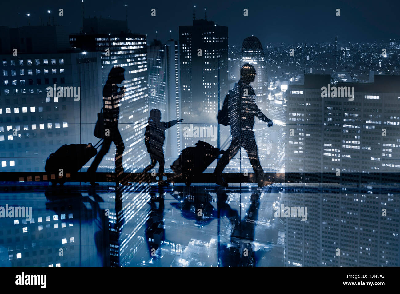 Double exposure of passengers walking with luggage and a beautiful aerial view of a large city with skyscrapers at night in back Stock Photo