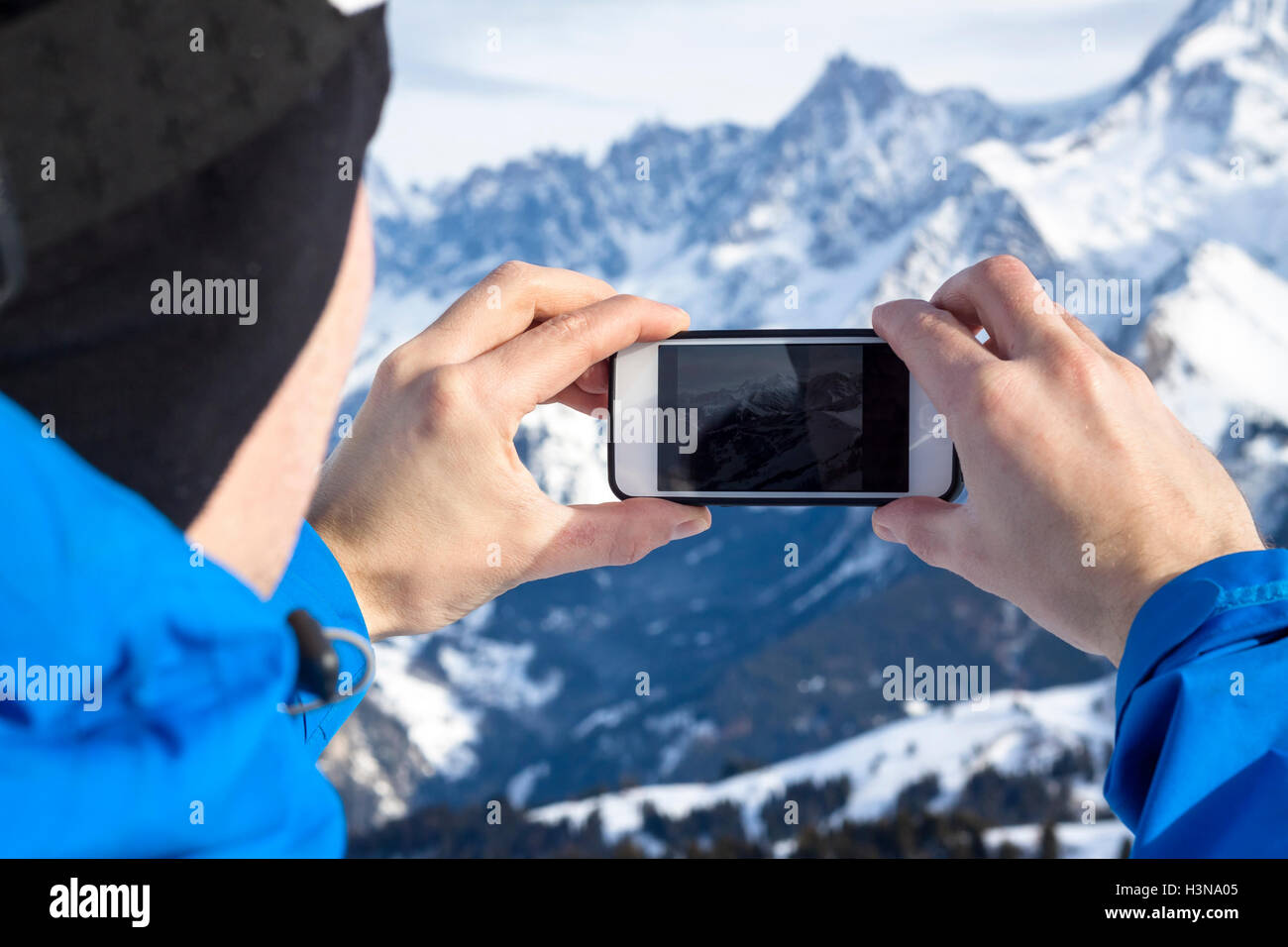 Skier taking photos with smartphone in hands Stock Photo