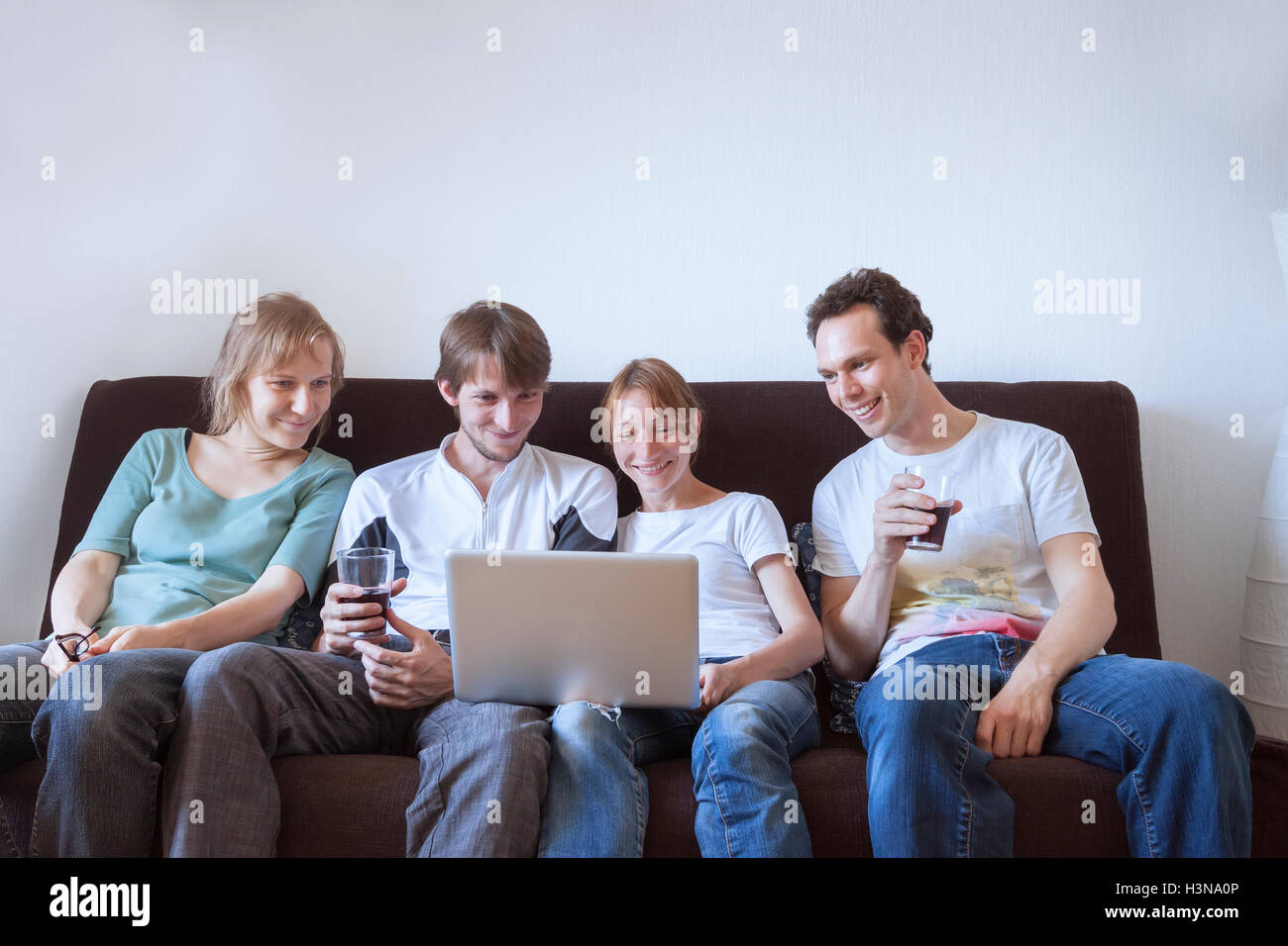 Group of friends laughing with laptop Stock Photo