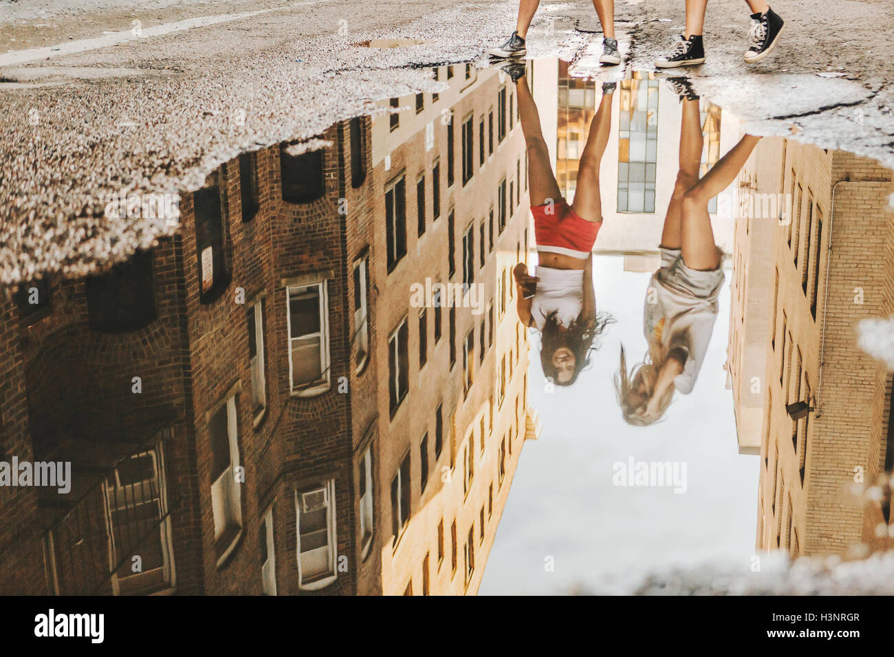 Women walking through puddle on road, Boston, MA, USA Stock Photo