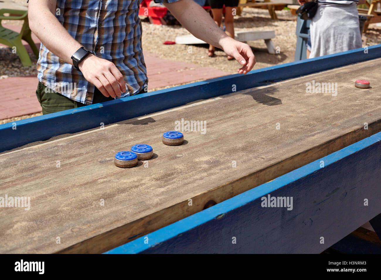 Young man playing table top shuffleboard, mid section Stock Photo Alamy
