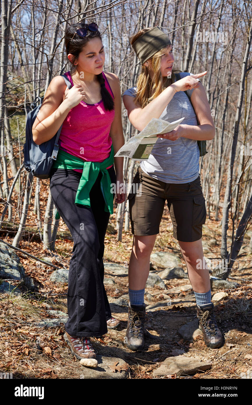 Two female hikers looking at map and pointing in forest, Harriman State ...
