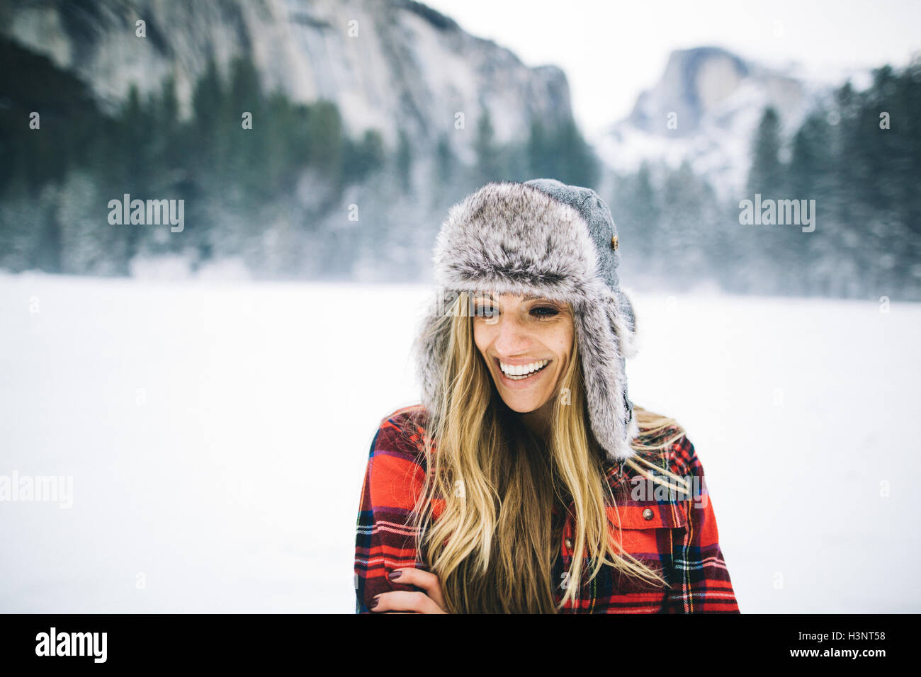 Rear view of woman wearing ushanka hat on snow-covered landscape Stock Photo