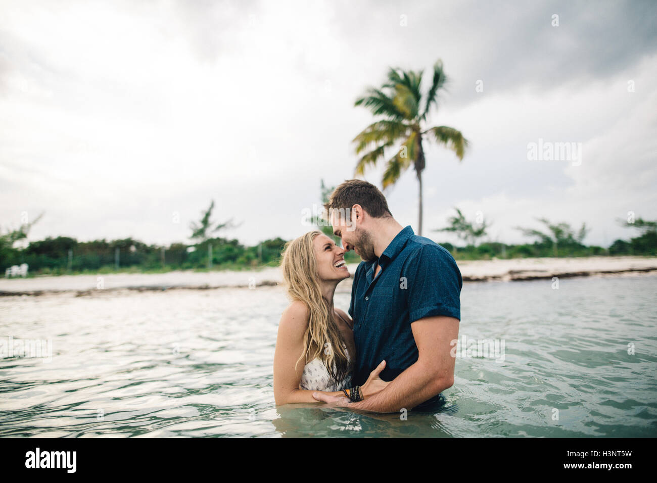 Couple waist deep in water face to face smiling Stock Photo