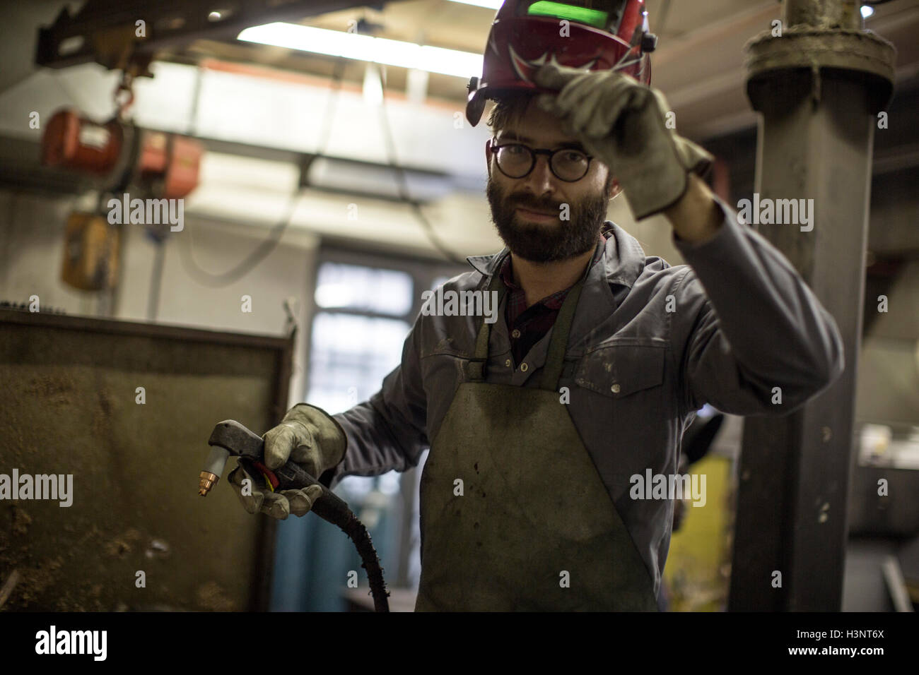 Welder holding welding torch looking at camera Stock Photo