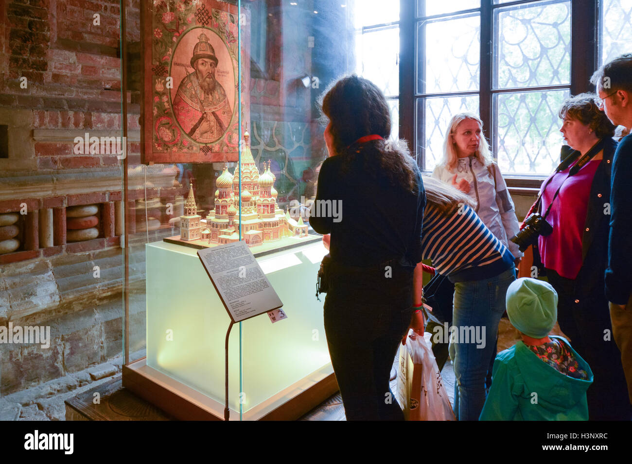 St Basils Cathedral Moscow interior - tourists looking at a model explaining the architecture - family with guide, girl with aud Stock Photo