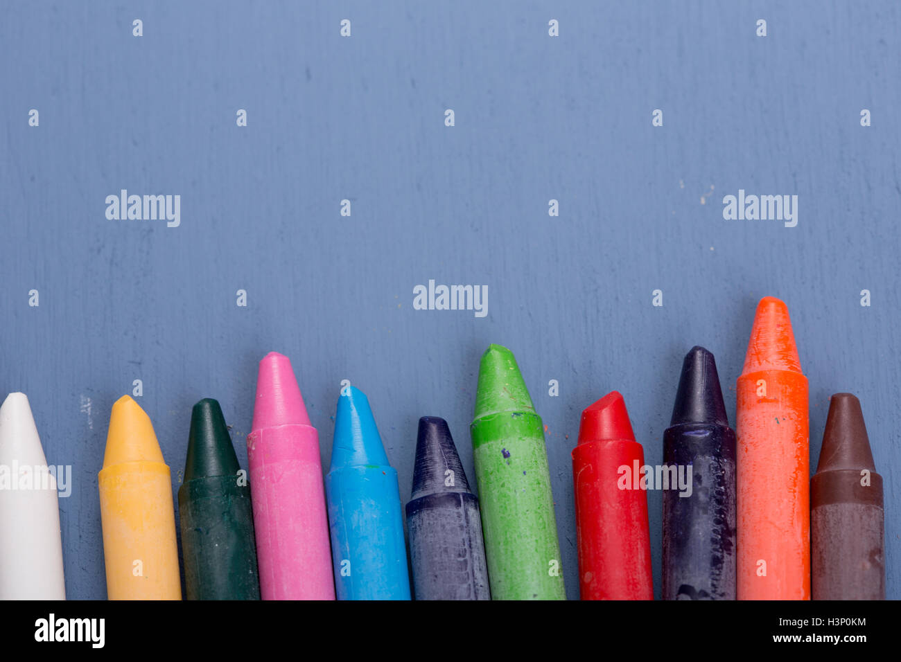 Wax crayons on a blue wooden background Stock Photo - Alamy