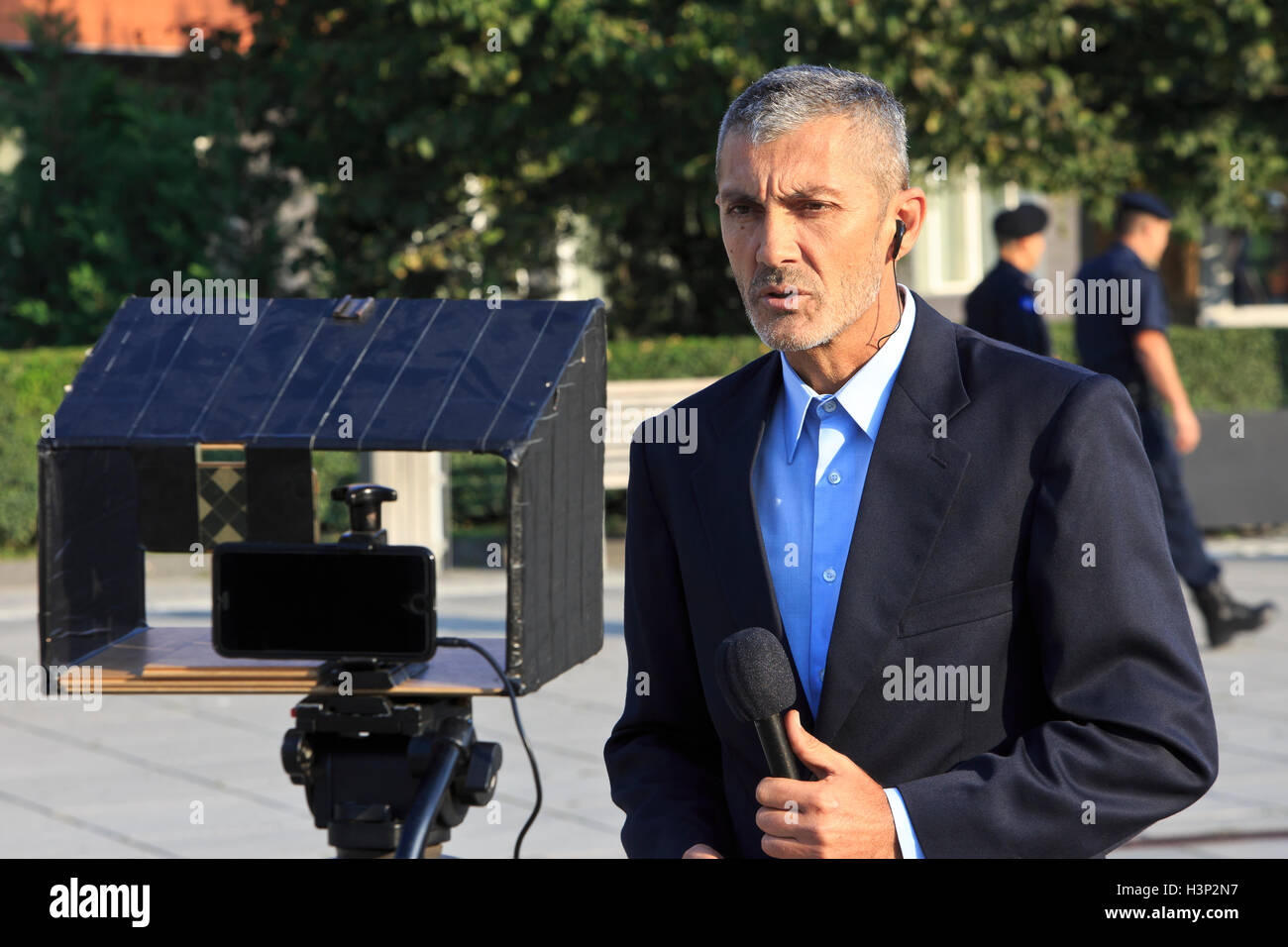 A reporter covering the protest outside the National Assembly in Pristina, Kosovo Stock Photo