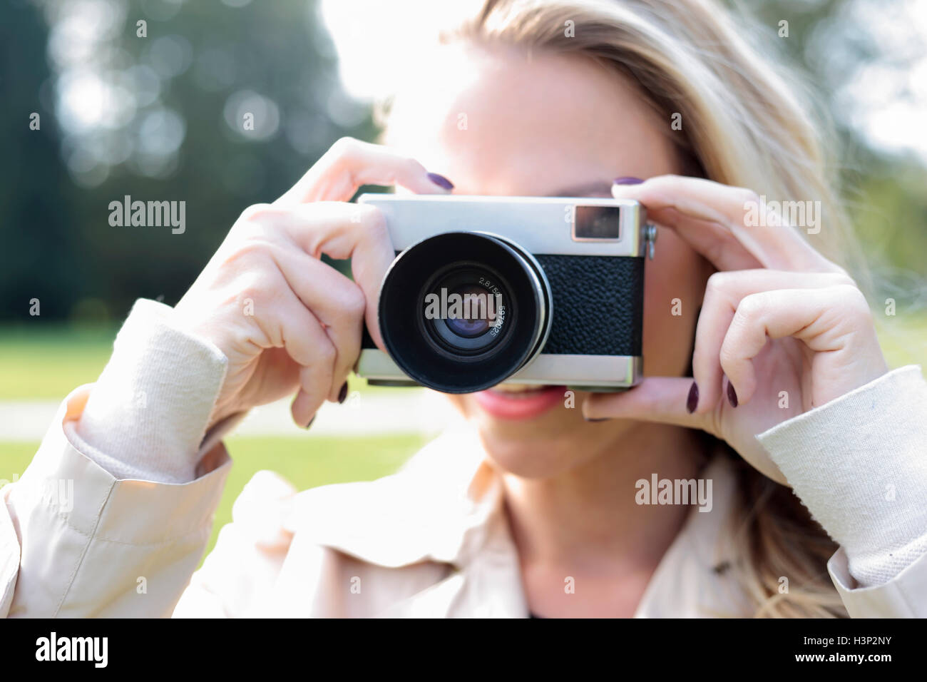Young woman taking photo with old foto camera Stock Photo