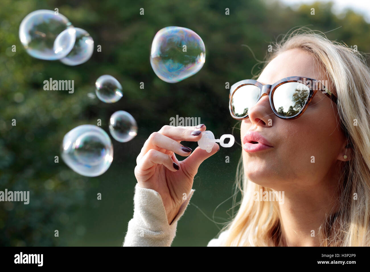 Young female blowing bubbles Stock Photo